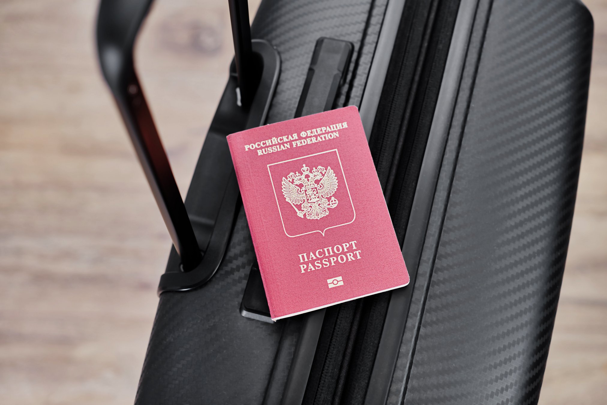 russian-passport-on-a-black-travel-suitcase-top-view-selective-background-emigration-of-russians-seeking-asylum.jpg
